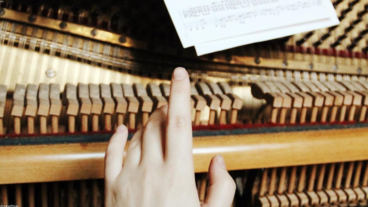 A pianist working out a melody by ear at the keyboard